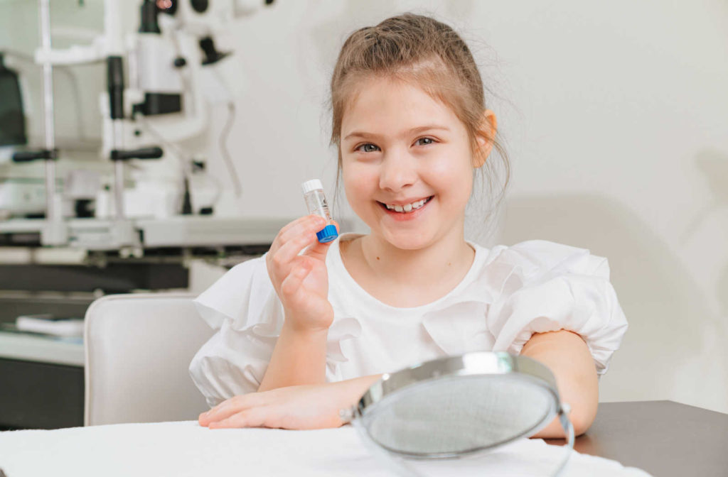 A child girl is holding a case with orthokeratological contact lenses. a modern method of vision correction technique that involves changing the shape of the cornea temporarily with progressively flatter hard contact lenses.