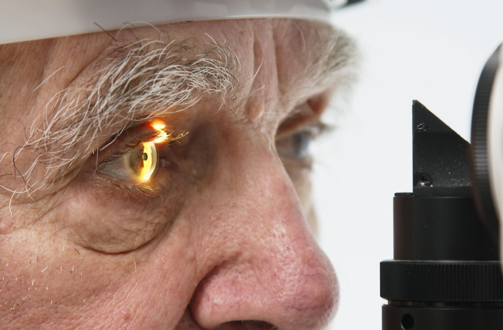 Close-up of an older man undergoing a slit-lamp exam.